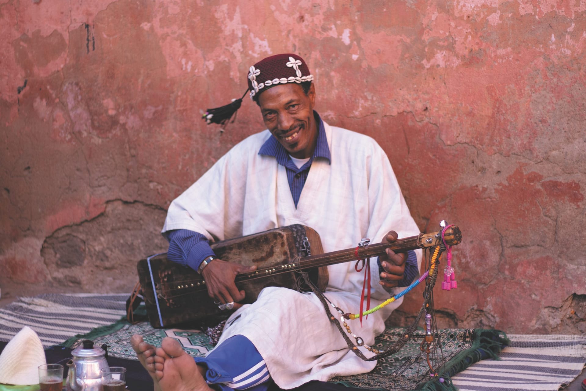 Musicien gnaoua dans la médina de Marraech au Maroc grattant son Guembri